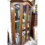 A contemporary walnut display cabinet, with bevelled glass panels, 124cm wide.