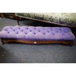 A Victorian carved walnut and button upholstered hearth stool, 118cm wide.