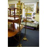 A pair of brass standard lamps, each with tripod base.