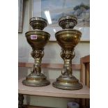 A pair of brass figural oil lamps.