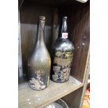 Two antique green glass wine bottles, one with later gilt decoration.