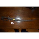 A 19th century Indonesian sword, having curved 49cm blade and carved wooden handle decorated dragon.