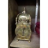 A small brass lantern style clock, 23.5cm high.