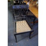 A set of three 19th century Anglo-Indian carved ebony and cane sabre leg dining chairs.