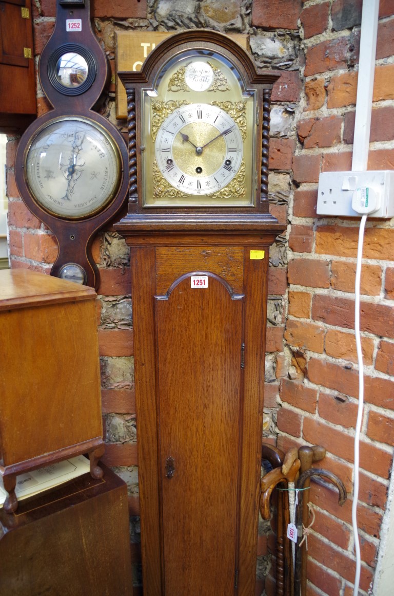 A 1920s oak musical mantel clock, on longcase stand, total height 173cm.