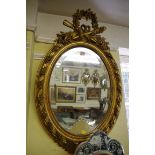 An antique gilt gesso framed oval wall mirror, 89 x 56.5cm.