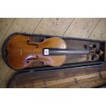 An antique Continental violin, with 14in back, in associated ebonized wood case.