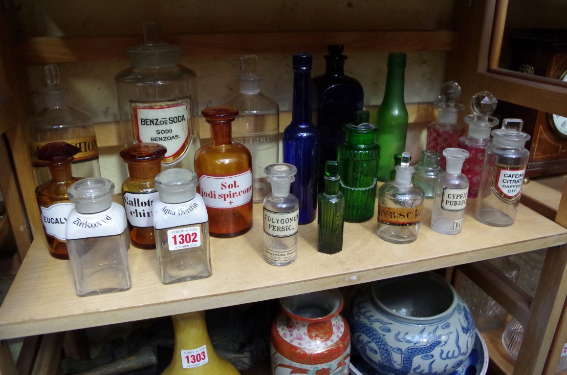 A collection of clear and coloured apothecary bottles.