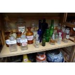 A collection of clear and coloured apothecary bottles.