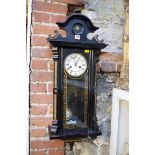 A late 19th century ebonized Vienna wall clock, spring driven, with pendulum.