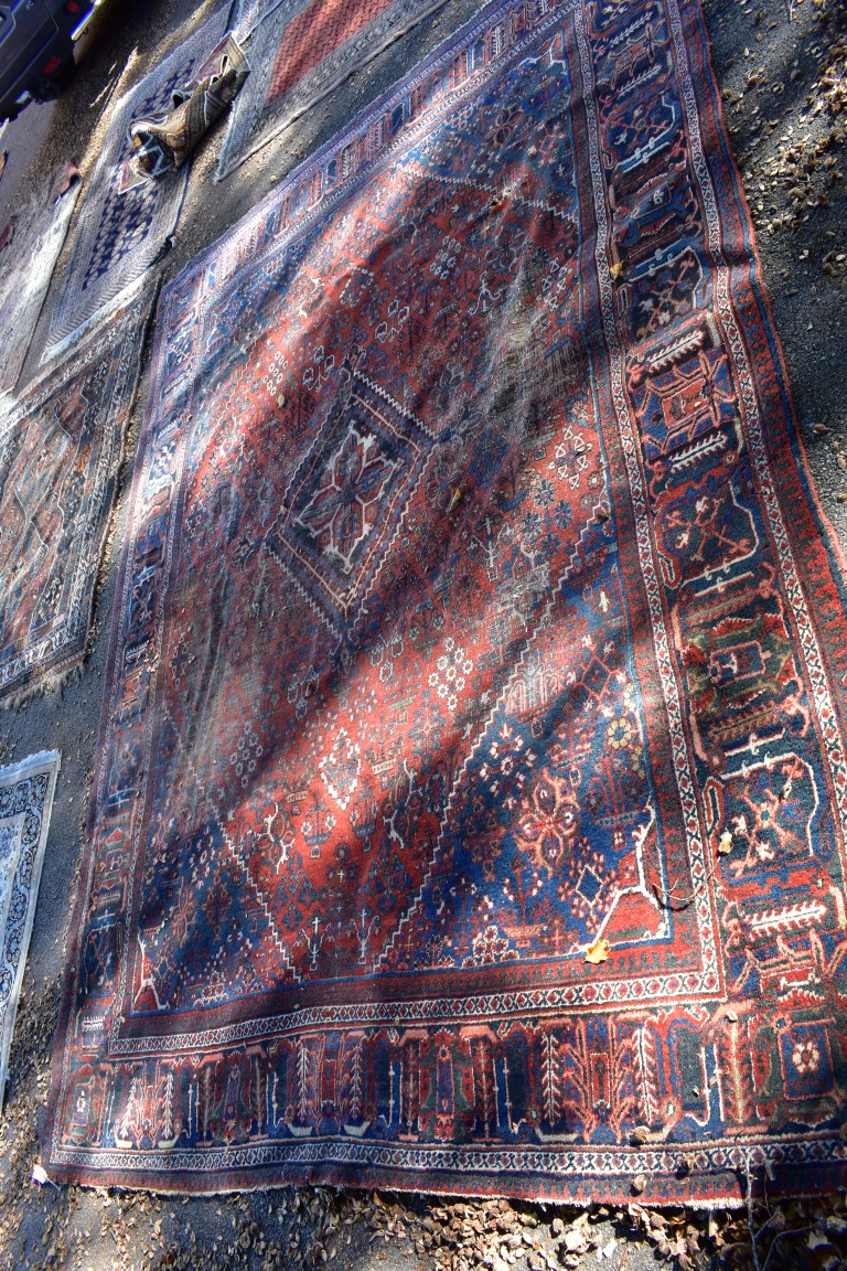 A large Persian rug, having central diamond medallion with allover floral central field, with