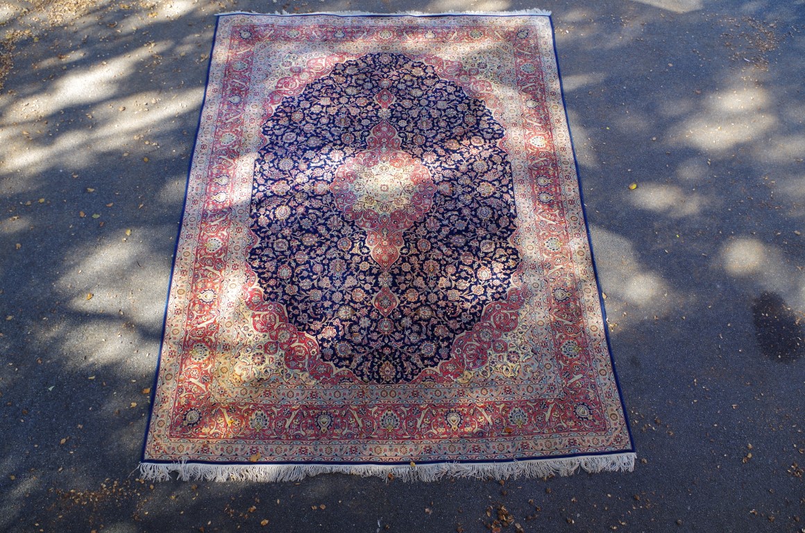 A fine and large Persian rug, having allover floral design on blue and salmon field, 406 x 297cm.