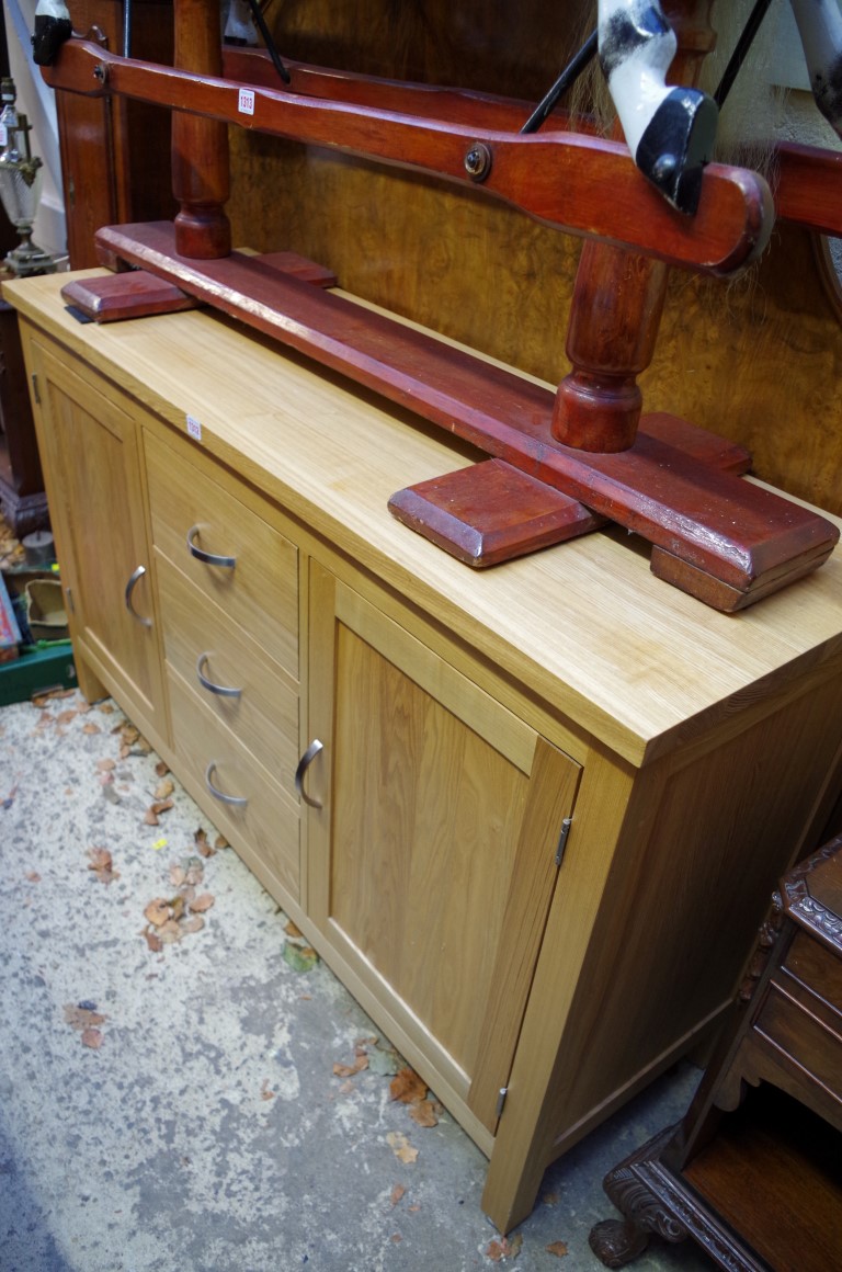 A contemporary pale oak side cabinet, 137.5cm wide.