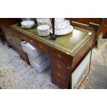 A campaign style teak and brass bound pedestal desk, with countersunk handles, 122cm wide.