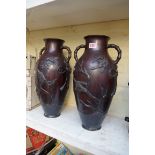 A  pair of large Japanese bronze twin handled vases, decorated in relief with birds and flowering