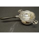 A silver tea strainer and stand, by Hukin & Heath, Birmingham 1945; together with a wooden handled