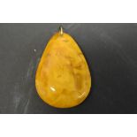 A large pear shaped butterscotch amber style pendant, 29.7g