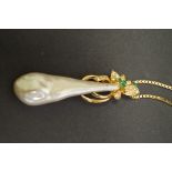 A floral emerald and diamond set baroque pearl pendant on 18ct gold box chain.