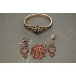 A small group of Victorian garnet set jewellery; comprising; a bangle; a pendant; and a pair of drop