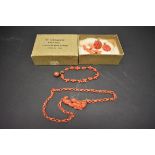 An antique carved coral chain having reclining cherub clasp; together with three other items of