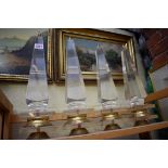 A set of four clear perspex and brass obelisks, 41cm high.