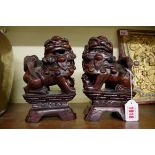 A pair of Chinese carved hardwood dogs of Fo, 19cm high.