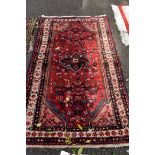 A Persian rug, having central field decorated figures and flowers, with geometric border, 175 x