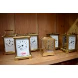 Six brass carriage timepieces, one with leather carry case.