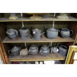 Eleven black basalt teapots, one with stand, three lacking covers, (s.d.)