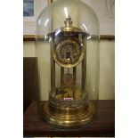 A brass mantel clock, 39cm high, with associated glass dome.