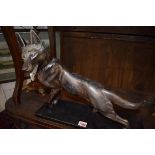 An Art Deco patinated model of a German Shepherd on ebonized wood base, total width 45cm.