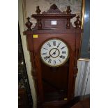 A stained oak Vienna style wall clock, spring driven, 88cm high, with pendulum.