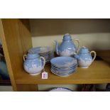 A Japanese porcelain part tea set, decorated with cranes against a pale blue ground.