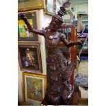 A large Burmese carved hardwood dancing figure, 126cm high, on associated mahogany stand.