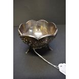 An early 20th century Japanese white metal bowl, decorated chrysanthemums on a hammered