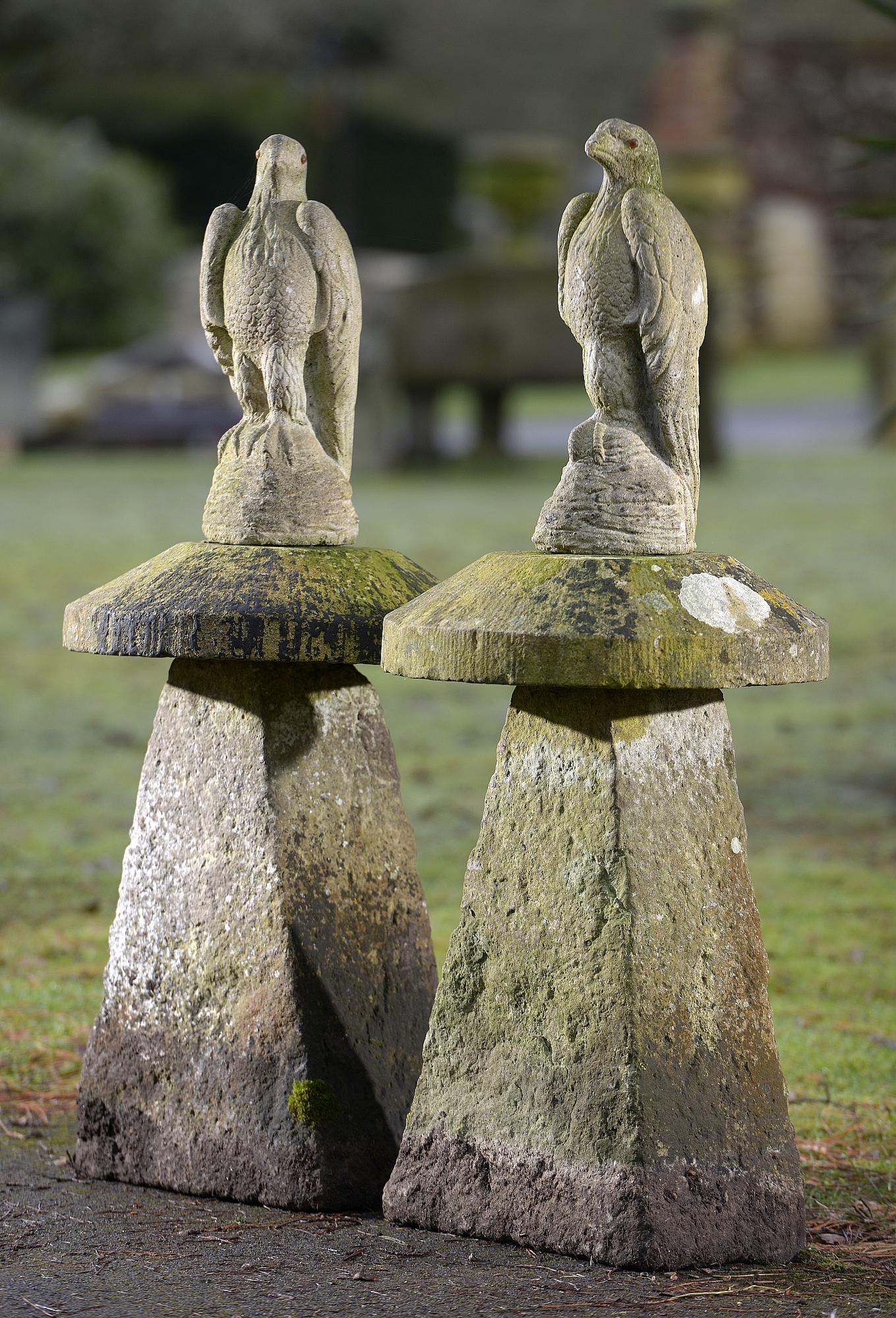 Garden Statuary: A pair of carved staddlestones with later composition stone eagles112cm high