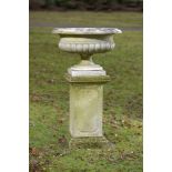 Planters: A carved white marble tazza shaped urn late 19th century on later carved limestone