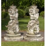Lighting: A pair of composition stone lamp bases cast with frolicking putti,2nd half 20th century
