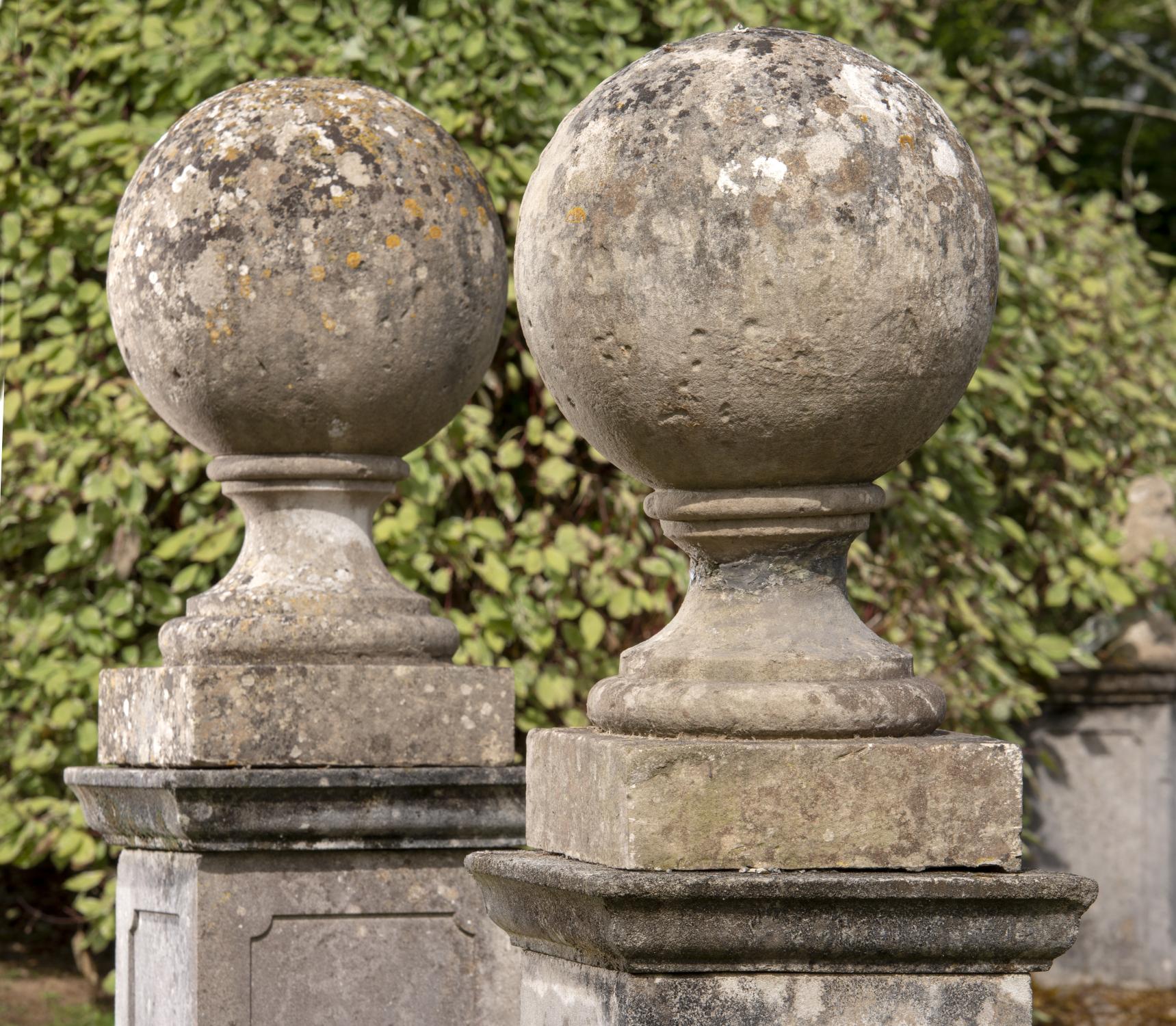 Architectural: A near pair of carved stone gate pier balls, 19th century, 76cm high by 46cm diameter
