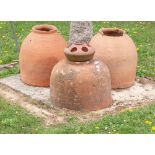 A harlequin set of three terracotta rhubarb forcers, early 20th century, one with lid, the largest