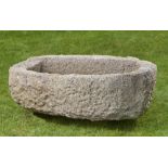 A carved stone irregular oval shaped trough, 33cm high by 110cm long by 70cm deep, together with a