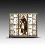 A late Victorian stained glass panel depicting a crusader in painted wooden frame158cm high by 176cm