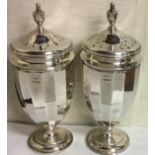 A CASED PAIR OF VINTAGE NEOCLASSICAL STYLE SILVER SUGAR CASTERS Having an urn shape finial and