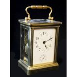 A 20th CENTURY GILT BRASS CARRIAGE CLOCK, four glass panels and the white dial having Arabic