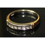 AN 18ct BI METAL AND DIAMOND HALF ETERNITY RING, having a single row of round cut diamonds,held in a