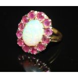 AN OPAL AND RUBY CLUSTER DRESS RING. An oval cabochon opal claw set to a surround of circular-cut