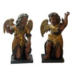 A PAIR OF 18TH CENTURY CARVED LIMEWOOD CHERUBS Both figures perched on one knee holding their arms