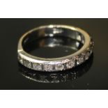 AN 18ct WHITE GOLD AND DIAMOND HALF ETERNITY RING, a single row of round cut diamonds in a plain