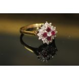 AN 18ct WHITE GOLD,RUBY AND DIAMOND CLUSTER RING, having four round cut rubies edged by a single row