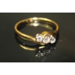 AN 18ct GOLD AND THREE STONE DIAMOND RING, having three graduating stones held in a cross over style